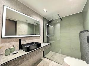 a bathroom with a sink and a mirror at Oasis Luxury Apartments in Eretria