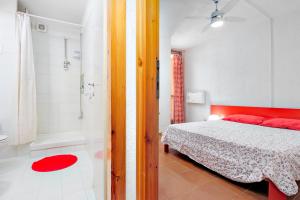a bedroom with a bed and a bathroom with a tub at Casa Vacanza Libeccio 2417 in Cugnana