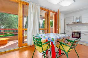 a dining room with a table and four chairs at Casa Vacanza Libeccio 2417 in Cugnana