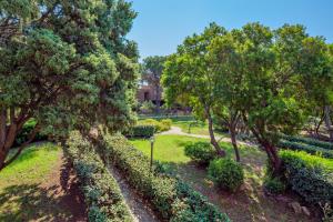 a park with trees and grass and a pathway at Casa Vacanza Libeccio 2417 in Cugnana