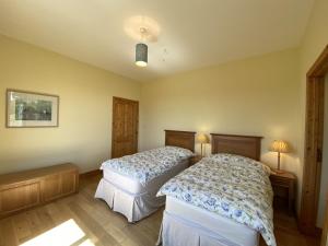1 dormitorio con 2 camas y 2 lámparas. en Property 450 - Oughterard, en Oughterard