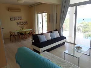 a living room with a couch and a table at Beachfront Residence With Private Path To The Sea in Poros