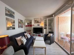 a living room with a couch and a tv at Appartement Saint-Aygulf, 2 pièces, 4 personnes - FR-1-226A-88 in Saint-Aygulf