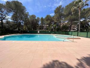 an empty swimming pool with a fence and trees at Appartement Saint-Aygulf, 2 pièces, 4 personnes - FR-1-226A-88 in Saint-Aygulf