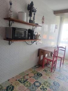 a kitchen with a table and a microwave at Apartamento en Plentzia en barrio muy tranquilo con aparcamiento gratuito y al lado del metro in Elejalde