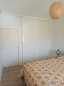 a bedroom with a bed and two white doors at Apartamento en Plentzia en barrio muy tranquilo con aparcamiento gratuito y al lado del metro in Elejalde