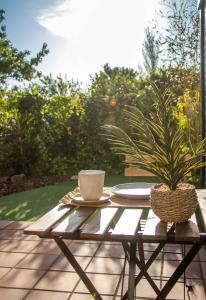 uma mesa com uma chávena de café e uma planta em vasos em CostaSerenaSuites em Nigrán