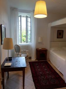 1 dormitorio con 1 cama, 1 mesa y 1 lámpara en Les 3 Platanes, en Conilhac-Corbières
