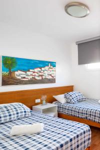 Habitación con 2 camas y una pintura en la pared. en Apartamento Maypa 1 Calma en San Bartolomé