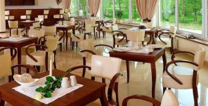 a restaurant with tables and chairs in a room at Ośrodek Wypoczynkowy Ariston in Miłków