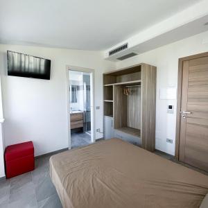 1 dormitorio con 1 cama y TV en la pared en Resort Policastro, en Policastro Bussentino