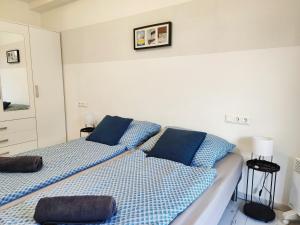 a bedroom with two beds with blue pillows at Petit Paul Apartman in Keszthely