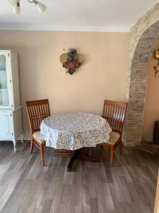 einem Esstisch mit 2 Stühlen und einem Tisch mit einem Tischtuch in der Unterkunft Apartments Neira near Dubrovnik in Ivanica