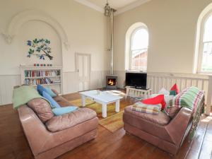 a living room with two couches and a table at Chapel House in Llangollen