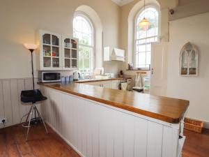 a large kitchen with a wooden counter top at Chapel House in Llangollen