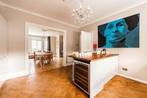 een keuken en eetkamer met een groot schilderij aan de muur bij Wellington House - Norfolk Holiday Properties in Lowestoft