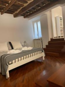 ein weißes Bett in einem Zimmer mit Treppen in der Unterkunft Vetus Auximon in Osimo