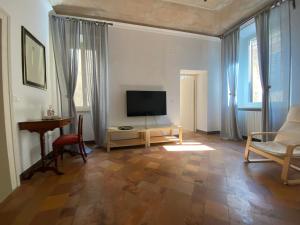 a living room with a television and a table at Vetus Auximon in Osimo
