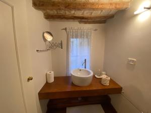 een badkamer met een wastafel op een houten aanrecht met een raam bij Vetus Auximon in Osimo