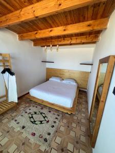 a bedroom with a bed and a wooden ceiling at Single fin beach house in Taghazout