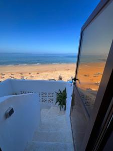 a view of the beach from the balcony of a house at Single fin beach house in Taghazout