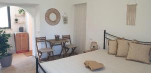 um quarto com uma cama, uma mesa e cadeiras em IL GIARDINETTO di Dilyana em Monterosi