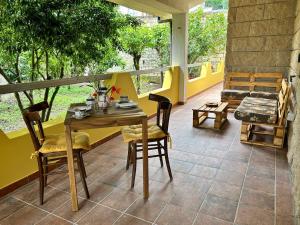 un patio con tavolo, sedie e divano di Locanda Su mere b&d a Cheremule