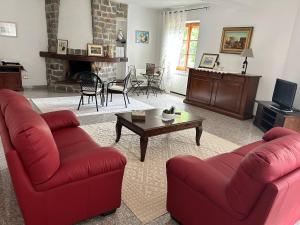 un soggiorno con 2 divani rossi e un tavolino da caffè di Locanda Su mere b&d a Cheremule