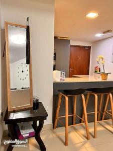 eine Küche mit einer Theke mit einem Spiegel und 2 Hockern in der Unterkunft One Bed Room Apartment Muscat Hills in Muscat