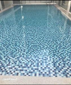 una piscina con suelo de baldosa azul y blanco en One Bed Room Apartment Muscat Hills en Mascate
