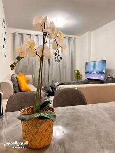 a vase with flowers on a table in a living room at One Bed Room Apartment Muscat Hills in Muscat