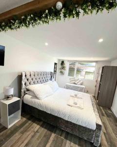 a bedroom with a large bed and a tv at Willow Inn in Kent