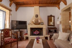 a living room with a fireplace and a tv at Villa Anastasia Kalyves in Kalyves