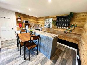 a kitchen with a bar and a table and chairs at Willow Inn in Kent