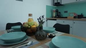 a table with a bowl of fruit and a bottle of wine at Apartma Relax in Prestranek