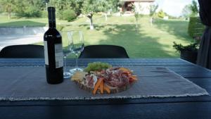 eine Flasche Wein und ein Teller mit Essen auf dem Tisch in der Unterkunft Apartma Relax in Prestranek