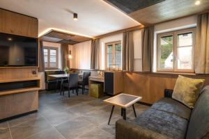 ein Wohnzimmer mit einem Sofa und einem Tisch in der Unterkunft Adlhof Apartments in Bruneck