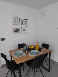 einen Holztisch mit schwarzen Stühlen und einen Tisch mit Tellern in der Unterkunft Apartma Relax in Prestranek