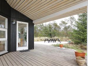 Sønder Vorupørにある8 person holiday home in Thistedの白いドアとピクニックテーブル付きの木製デッキ