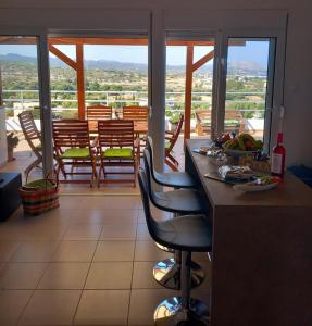 a kitchen with chairs and a counter with a view of a balcony at Katerinas Roof House in Gennadi