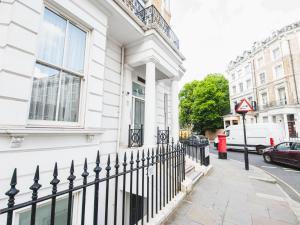 ロンドンにあるPass the Keys Earl's Court Top Floor Apartmentの白い建物の前の黒い柵