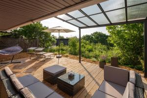 um pátio com cadeiras, uma mesa e um guarda-sol em RhönKristall modernes Terrassenhaus mit Weitblick em Bischofsheim an der Rhön