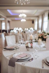 Hotel Hetman في كروتشيسته: طاولة مع قماش الطاولة البيضاء والأطباق والفضيات