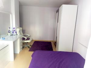 una camera con letto viola e armadietto bianco di Modern apartment in Burgas a Burgas