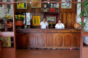 two people standing at a bar in a restaurant at Hotel Boyeros in Liberia