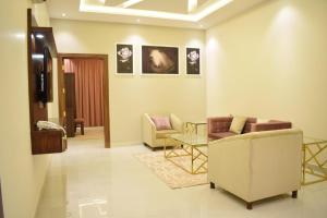 sala de estar con 2 sillas y mesa en AlMogheeb units en Riad