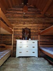 een slaapkamer met 2 bedden en een dressoir in een hut bij Charmig gård med bastu, strandtomt och utedusch i naturskönt område in Sveg