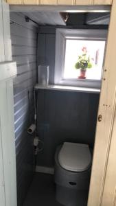 een kleine badkamer met een toilet en een raam bij Charmig gård med bastu, strandtomt och utedusch i naturskönt område in Sveg