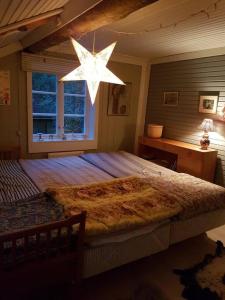 a bedroom with a large bed with a large star chandelier at Charmig gård med bastu, strandtomt och utedusch i naturskönt område in Sveg