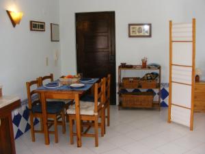 uma sala de jantar com uma mesa de madeira e cadeiras em Apartamento Navegantes em Sintra